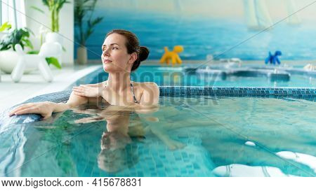 A Beautiful Adult Girl Is Enjoying A Visit To The Pool With Hydromassage In The Aquazone Of The Spa 