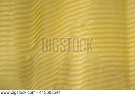 Full Frame Background Texture Of Ripples In Yellow Margarine. Possible Healthier Food Choice To Trad