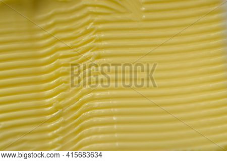 Super Macro Image Of Spreadable Yellow Margarine, After Having A Kitchen Knife Run Through It To Cre