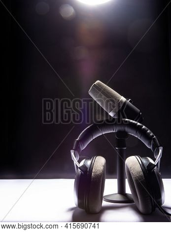 Professional Condenser Microphone And Headset On White Surface And Black Background, Low Key Portrai