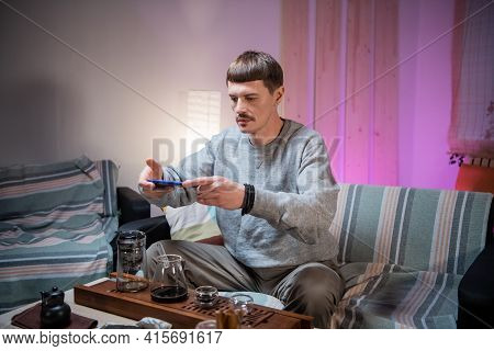 A Young Man Takes Pictures For Social Networks On A Smartphone. Photographs A Bamboo Gongfu Tray And
