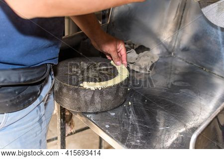 Man Putting Dough On Millstone To Be Able To Assemble Well