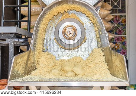 Front View Of A Nixtamal Mill With A Lot Of Dough Inside It