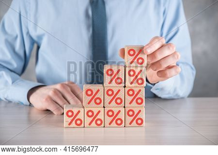 Businessman Hand Takes A Wooden Cube Block Depicting,shown The Percentage Symbol Icon. Interest Rate