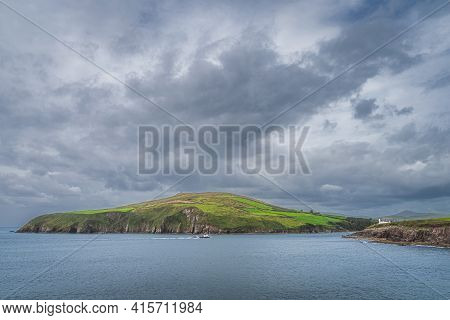 Dingle Lighthouse Guiding Fishing Boats Returning To The Village. Dramatic Storm Clouds Over Dingle 