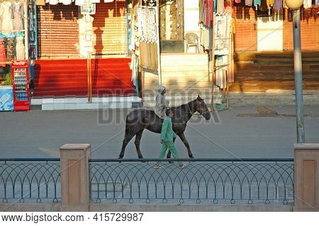 EDFU, EGYPT - OCTOBER 31: Children ride their horse past shops in Edfu, Egypt, October 31, 2008. Horses are still a part of everyday life in many places in the Middel East.