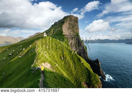 Kallur lighthouse on green hills of Kalsoy island