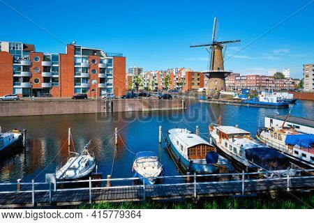 View of the harbour of Delfshaven and the old grain mill De Destilleerketel. Rotterdam, Netherlands
