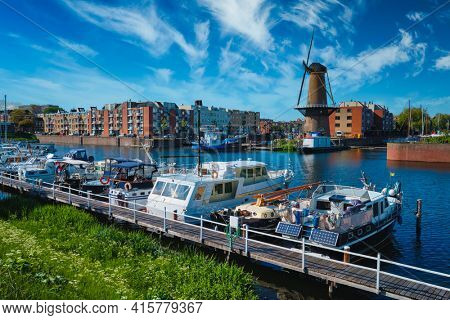 View of the harbour of Delfshaven and the old grain mill De Destilleerketel. Rotterdam, Netherlands