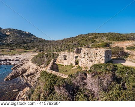 A Derelict Stone Building Standing On The Rocky Coast Of La Revellata By A Turquoise Mediterranean B