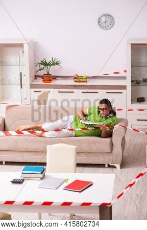 Young male student studying at home in self-isolation concept