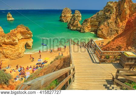 Lagos, Portugal - August 21, 2017: Wooden Walkway Staircase To Scenic Praia Do Camilo With Clear Wat