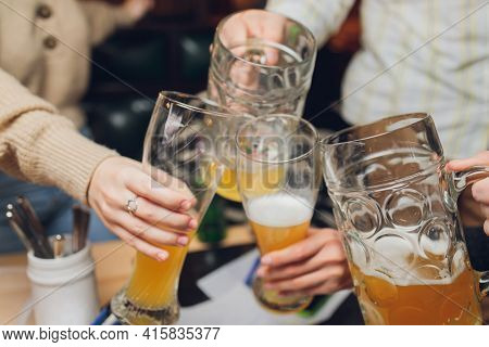 Four Friends With A Fresh Beer In A Beer Garden Close-up On Beer Stein.