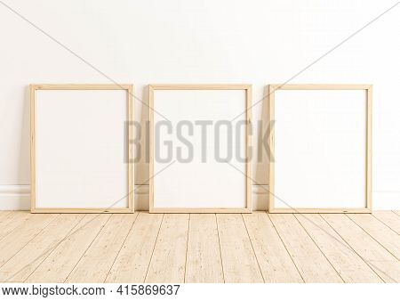 Triple 8x10 Vertical Wooden Frame Mockup On Wooden Floor And White Wall. Three Empty Poster Frame Mo