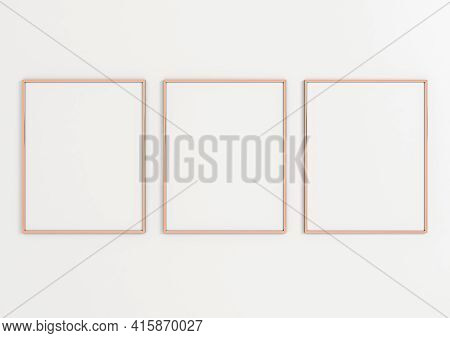 Triple 8x10 Vertical Rose Gold Frame Mockup On White Wall. Three Empty Poster Frame Mockup On White 