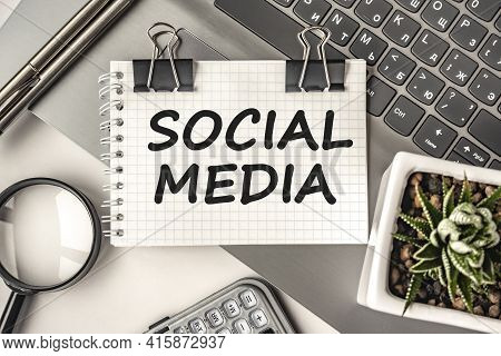 Social Media Text On A Notepad And Laptop, Office Tools. Business, Financial Concept. Remote Trainin