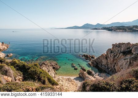 A Small Pebble Beach And Translucent Mediterranean Sea On The Coast Of La Revellata In The Balagne R