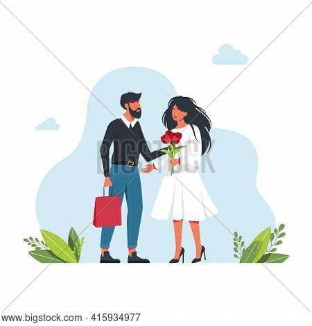 Man Gives Woman Flowers And A Gift. A Cute Man Gives A Present To A Woman With A Bouquet Of Flowers.