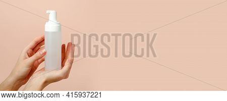 Female Hand With Cosmetic Product In Bottle On Neutral Beige Trendy Background, Concept Of Helathcar