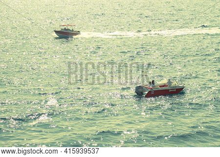 Two White Fast Boats Sails By Sea. Sunny Autumn Day. Side View. Crimea, Sudak - 10 October 2020.