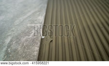 Construction Worker Tiler Is Tiling, Tiler Installing Ceramic Tiles On A Floor. Industrial Tiler Lay