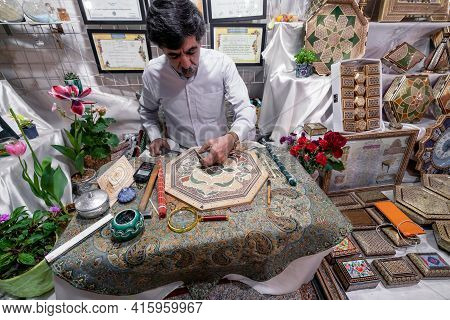Shiraz, Iran - 04.10.2019: Iranian Khatam Master Woking Behind The Desk In His Shop In Shiraz, Iran.