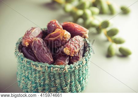 Very nutritious ripen dates stored in a tiny basket placed along with bunch of green dates. Best quality dates from Saudi.