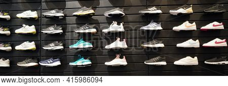Shop Display Of A Lot Of Sports Shoes On A Wall. A View Of A Wall Of Shoes Inside The Store. Modern 