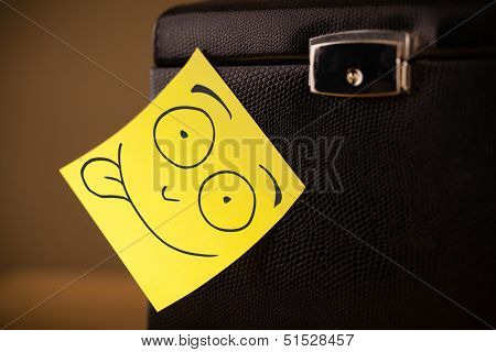 Drawn smiley face on a post-it note sticked on a jewelry box