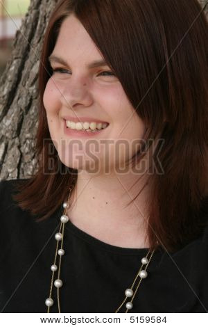 Headshot sorridente da menina olhando para o lado
