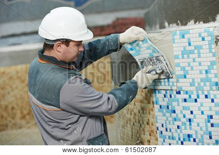 industrial tiler builder worker installing floor tile at repair renovation work
