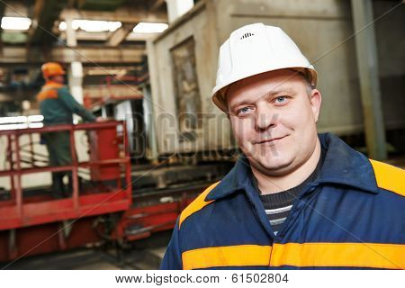 portrait of positive adult industrial worker at factory workshop