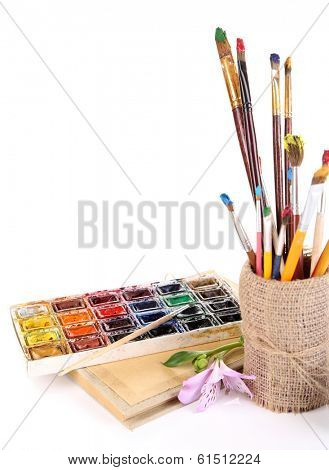 Composition with brushes in vase and paints isolated on white