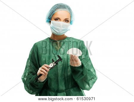Plastic surgeon woman with silicon breast implants and calliper 