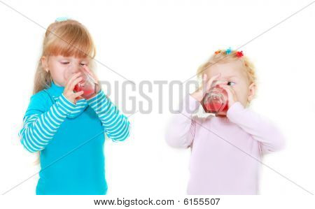 Two Girls Drinking Juice Over White