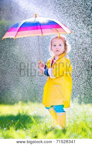 Funny Toddler With Umbrella Playing In The Rain