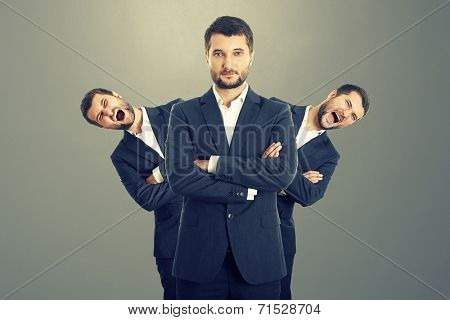 two screaming men behind confident businessman over dark background