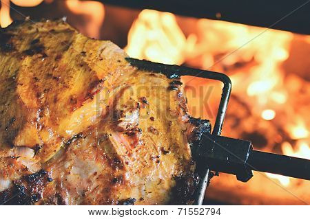 Grilled meat with flames in the background