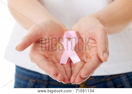 Womans hands holding pink breast cancer awareness ribbon