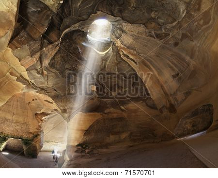 Israel National Park.  Picturesque clay arches illuminated by the sun from the hole at the top and side entrances. Bell caves of Beit Guvrin