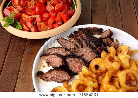 Flank Steak With Fries Onion Rings And Salad