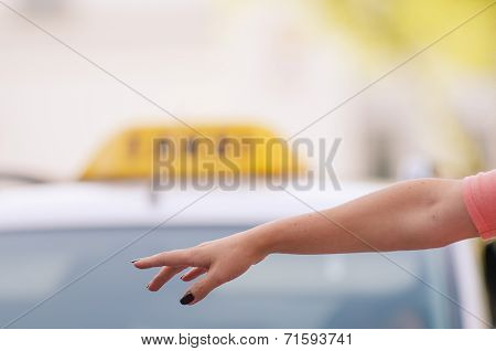 woman raising her arm to call a taxi