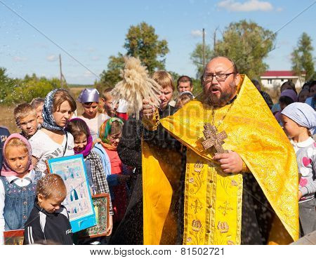 Priest Sprinkling Holy Water On People