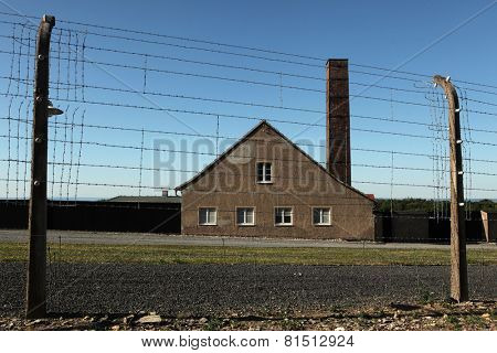 WEIMAR, GERMANY - JUNE 21, 2013: Crematorium and electrified barbed wires in the Buchenwald concentration camp near Weimar, Germany.