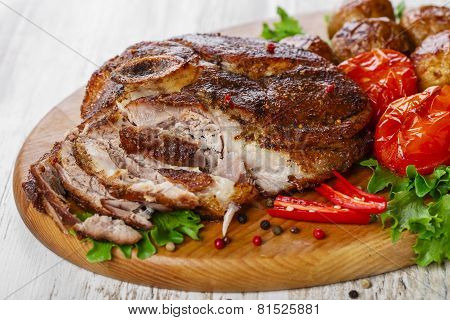 roasted pork shoulder on the bone with potatoes