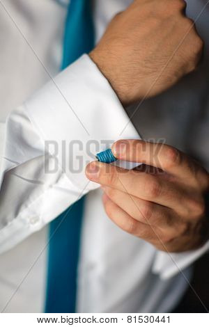 Man's Hands Closeup Fixing His Blue Cufflinks