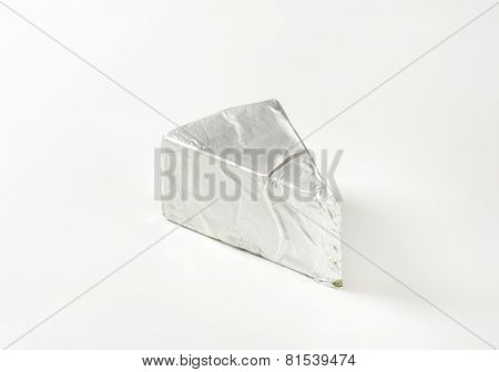 triangle of cheese packed into aluminum foil