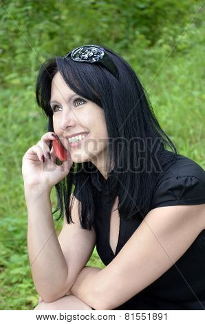 A Smiling Girl In A Black Dress With A Red Phone