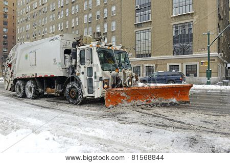 Truck with snowplow clearing street after snowstorm
