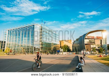 People are relaxing in front of the Kiasma museum and Sanoma bui